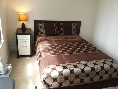 a bedroom with a large bed with a nightstand and a bed sidx sidx sidx at 2 Bedroom 1 Bathroom Prime Location in Mississauga in Mississauga