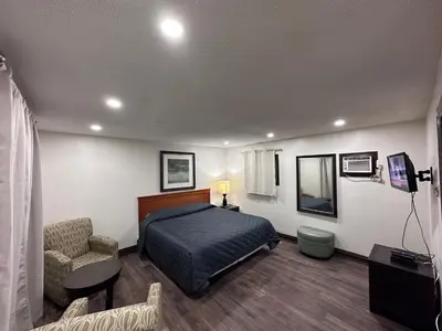 a bedroom with a bed and a chair in a room at Cedar Springs Motel in Acton