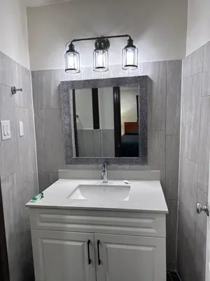 a bathroom with a white sink and a mirror at Cedar Springs Motel in Acton