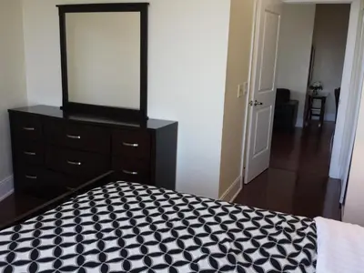a bedroom with a black dresser and a mirror at 2 BEDROOM 2 Bathroom Best Value Prime Location in Missisauga in Mississauga