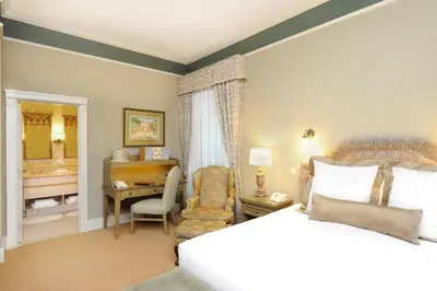 a bedroom with a bed and a desk and a chair at Old Mill Toronto Hotel in Toronto