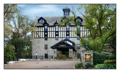 a large black and white building with a sign in front at Old Mill Toronto Hotel in Toronto