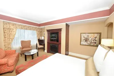 a hotel room with a bed and a living room at Old Mill Toronto Hotel in Toronto