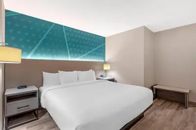 a bedroom with a white bed and a green wall at Comfort Inn in Bracebridge