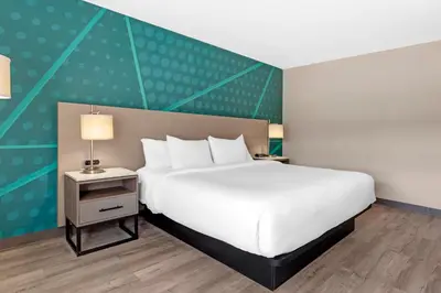 a bedroom with a large white bed and a green wall at Comfort Inn in Bracebridge