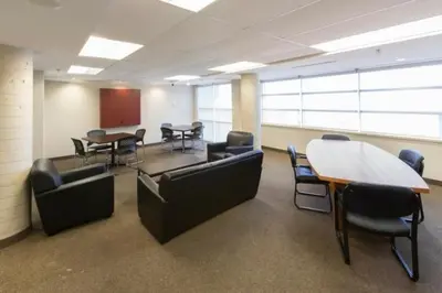 a conference room with couches and a table and chairs at Residence & Conference Centre - Oshawa in Oshawa