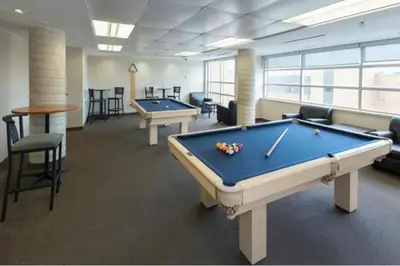 a billiard room with two pool tables and chairs at Residence & Conference Centre - Oshawa in Oshawa