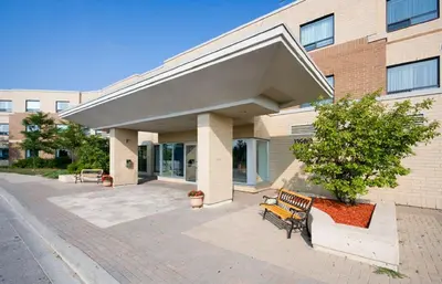 a bench in front of a building at Residence & Conference Centre - King City in King City
