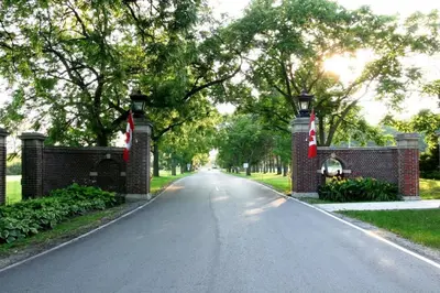 an empty street with a brick fence and a driveway at Residence & Conference Centre - King City in King City