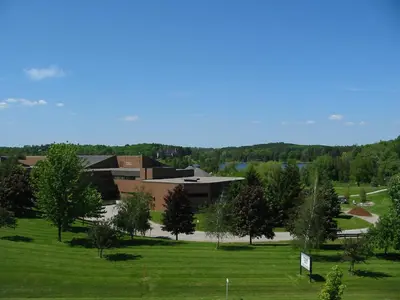 a campus with a building and a field with trees at Residence & Conference Centre - King City in King City