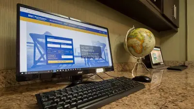 a computer monitor with a keyboard and a mouse and a globe at Best Western Plus Durham Hotel & Conference Centre in Oshawa