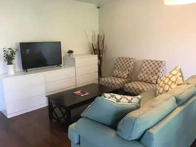 a living room with a couch and chairs and a tv at Home Base in Markham