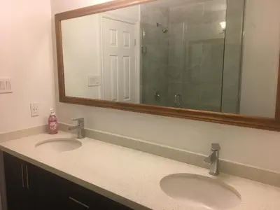 a bathroom with two sinks and a large mirror at Home Base in Markham
