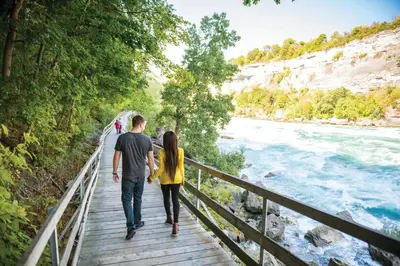 a man and woman walking on a bridge over the river at Holiday Inn Express Niagara-On-The-Lake by IHG in Niagara on the Lake