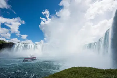 a boat in the water in front of a waterfall at Staybridge Suites Niagara-On-The-Lake by IHG in Niagara on the Lake