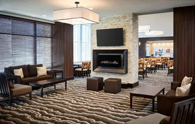 a hotel lobby with a fireplace and a dining room at Staybridge Suites Niagara-On-The-Lake by IHG in Niagara on the Lake