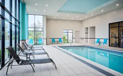 an indoor pool with chairs and a swimming pool at Staybridge Suites Niagara-On-The-Lake by IHG in Niagara on the Lake