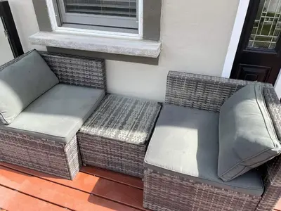 a wicker couch sitting on a porch next to a window at Globetrotters B&B in Niagara on the Lake