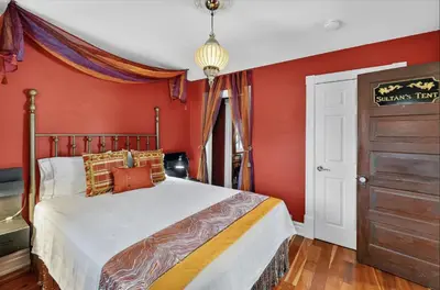 a bedroom with red walls and a bed in a room at Globetrotters B&B in Niagara on the Lake