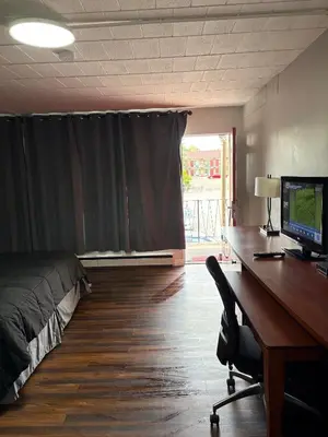 a room with a desk with a computer and a bed at Advance Inn in Niagara Falls