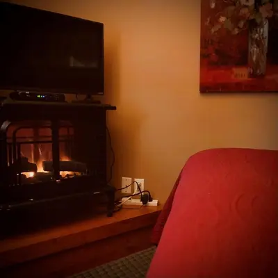 a bedroom with a fireplace with a television on it at WeatherPine Inn in Niagara on the Lake