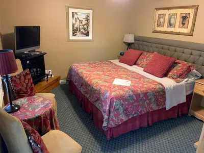a hotel room with a bed and a tv at WeatherPine Inn in Niagara on the Lake