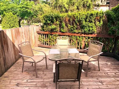 a patio with a table and chairs and a fence at WeatherPine Inn in Niagara on the Lake