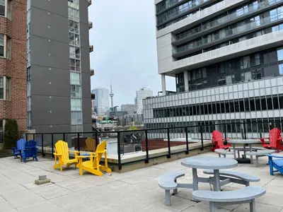 a group of tables and chairs in front of a building at Neill Wycik Hostel in Toronto