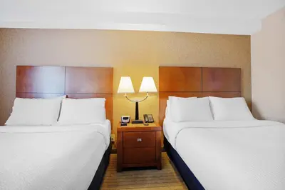 two beds sitting next to each other in a room at Sandman Hotel & Suites London Downtown in London