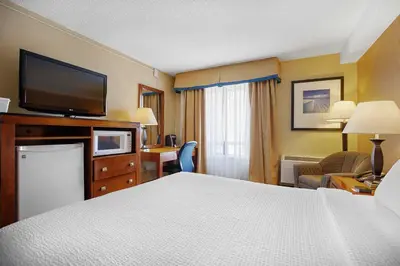 a hotel room with a bed and a flat screen tv at Sandman Hotel & Suites London Downtown in London