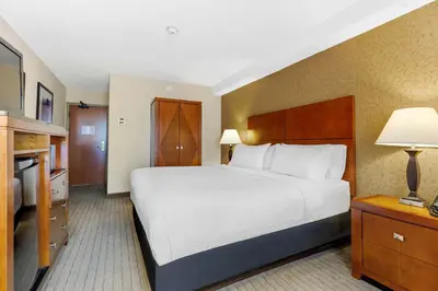 a hotel room with a large bed and a television at Sandman Hotel & Suites London Downtown in London