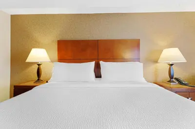 a bedroom with a large white bed with two lamps at Sandman Hotel & Suites London Downtown in London