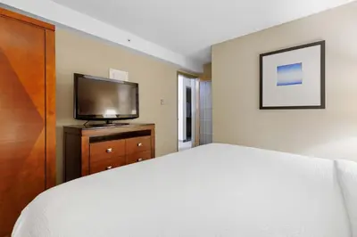 a bedroom with a bed and a flat screen tv at Sandman Hotel & Suites London Downtown in London