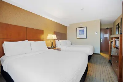 a hotel room with two beds and a television at Sandman Hotel & Suites London Downtown in London