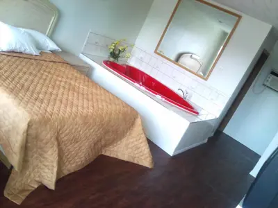 a bathroom with a red sink and a bed at Rainbow Motor Inn - Fallsview in Niagara Falls