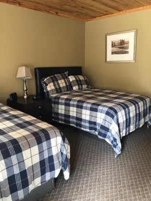 a bedroom with two beds and a lamp on a table at Noble Motel in Norland
