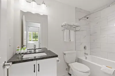 a white bathroom with a toilet and a sink at Touchstone Resort in Bracebridge