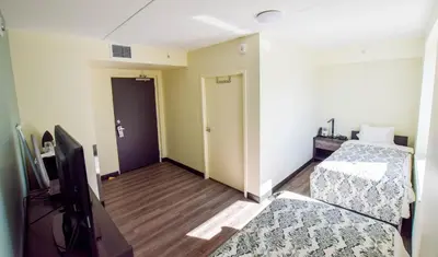 a room with two beds and a flat screen tv at United College in Waterloo