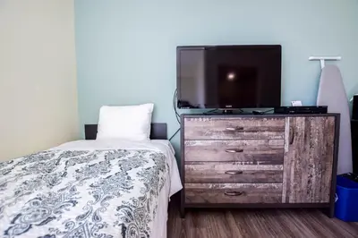 a bedroom with a bed and a tv on a dresser at United College in Waterloo