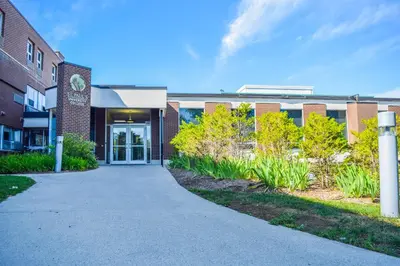 a brick building with a walkway in front of it at United College in Waterloo
