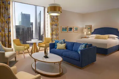 a hotel room with a bed and a blue couch at Hilton Toronto in Toronto