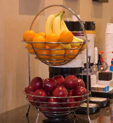 a basket of fruit on a counter with apples and oranges at Hampton Inn Toronto-Mississauga West in Mississauga