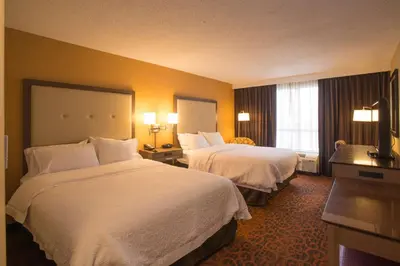 a hotel room with two beds and a window at Hampton Inn Toronto-Mississauga West in Mississauga