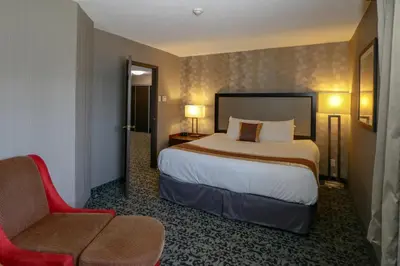 a hotel room with a bed and a chair at Ramada by Wyndham Jackson's Point in Georgina