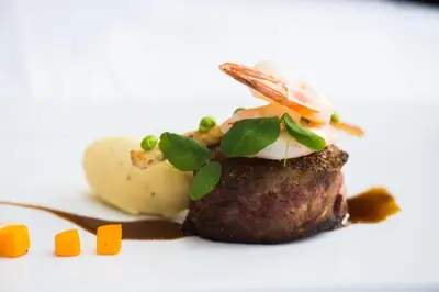 a piece of meat with vegetables on top of it at Prince of Wales in Niagara on the Lake
