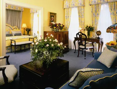 a living room with a blue couch and a bedroom at Prince of Wales in Niagara on the Lake