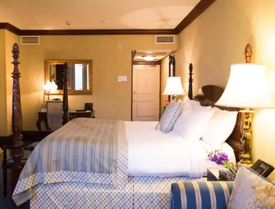 a hotel room with a bed and two lamps at Prince of Wales in Niagara on the Lake