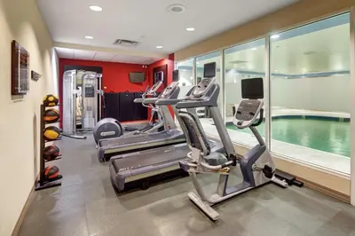 a gym with several treadmills and a swimming pool at Hilton Garden Inn Toronto-Oakville in Oakville