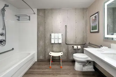 a bathroom with a tub and a toilet and a sink at Hilton Garden Inn Toronto-Oakville in Oakville