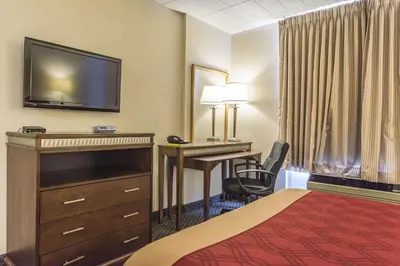 a hotel room with a bed and a desk and a television at Econo Lodge in Orillia